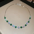 Close-up of a silver necklace with alternating green and white circular zircon stones - Green-White Necklace