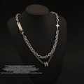 Detail of silver double-layer star necklace with pavé ring pendant on black bust - Black
