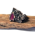 Détail d'une bague artisanale en bronze avec améthyste brute sur support en bois - Rubis Brut