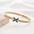 Goldener Edelstahl-Armreif mit X-förmigem blau-schwarzem Emaille und Zirkonia-Besatz - Blau Schwarz Emaille & Pave Zirkonia