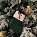 Green knit Christmas stocking with white cuff and red embroidered letter X on a snowy tree - Green/Letter X