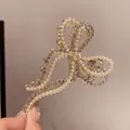 Elegant gold butterfly hair claw clip with inlaid white pearls and sparkling rhinestones - Golden Rhinestone Pearl Bow Hair Claw