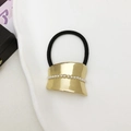 Macro-opname van zwarte haarelastiek met gouden legering en parels voor een lage paardenstaart - Goud