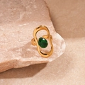 Detail van gouden ring met groene ovale zirkoon op een steen met textuur achtergrond - Groen Ovaal Frame