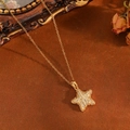 Detail of gold star pendant necklace with cubic zirconia on vintage brown background - Gold Full Diamond Star Necklace