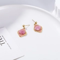 Macro detail of gold-plated leaf earrings with pink enamel in a white ceramic dish - Pink Ruyi Stud Earrings Style (EH003)