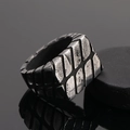 Dettaglio macro di anello industriale da uomo in acciaio al titanio con trama a rilievo - US 8 / Argento antico