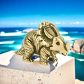 Detailed view of miniature bronze triceratops figurine with realistic skin texture on rock - Triceratops