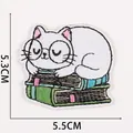 Detail of cartoon cat embroidery patch on books with dimensions 5.5cm x 5.3cm - No.17 (Cat Reading)