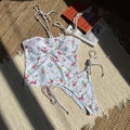 Nahaufnahme von floralem Bikini mit Neckholder-Top und seitlich gebundenem Unterteil - S / Weiß Blumig