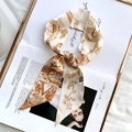 Elegant beige silk twilly scarf with brown animal print tied on a magazine - Sketch Spring Letter V
