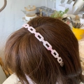 Close-up of pink acetic acid cube chain headband worn on hair with minimalist geometric style - Pink