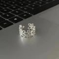Adjustable silver hollow flower ring with black agate inlay on a laptop keyboard - Hollow Floral Pattern Ring (J3637)