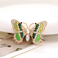 Dettaglio macro di accessorio a farfalla in lega di zinco con cristalli e smalto - Verde
