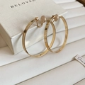 Detailansicht der breiten goldenen Clip-Ohrringe mit Silikonpolstern für ungestochene Ohren - Clip-on-Stil / Gold