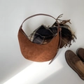 Brown suede crescent bag with leather strap shown in a cozy autumn styled arrangement - Coffee