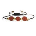 Macro shot of hand-woven bracelet with red jasper stones and golden metal beads - Red Sesame