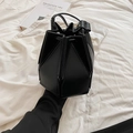 Minimalist black geometric folding bucket bag with structural paneling and round handle - Black