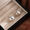 Polished silver teardrop stud earrings with a glossy mirror finish on a velvet display - Silver Half Moon