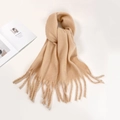 Close-up of soft apricot mohair scarf featuring elegant fringe ends and cozy texture - Camel