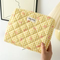 Detail of yellow gingham quilted makeup bag with pink bow pattern and brand label - Medium / Yellow Grid with Bow