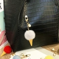 Close-up detail of cute plush ice cream keychain with pearl charm on a black textured bag - Single Piece / Gray