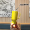 Detailed close-up of a 2oz 60ml yellow mini stainless steel tumbler with handle and straw - 2oz/60ml / Yellow