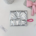 Close-up of silver quilted makeup bag with butterfly texture and pink wrist strap - Bow Quilted Silver Square Sanitary Pad Bag