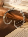 Dettaglio macro di orecchini a cerchio in strass argento su una scatola portaoggetti in legno - Argento
