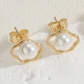 Macro-opname van elegante goudkleurige wolk-oorringen met witte parelmoer inleg - Wolk Oorknopjes