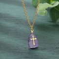 Vue détaillée du pendentif croix en pierre naturelle violette avec chaîne dorée en acier - Glycine
