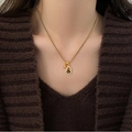 Gros plan du collier gourde plaqué or 18 carats avec pierre œil de tigre et cristaux sur pull - 85# Collier Gourde Strass Doré Café