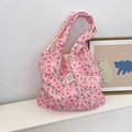 Detailed texture of pink tulip floral quilted tote bag on a white platform - Lusi Portrait