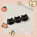 Detail shot of black acetate hair clip with three golden-detailed cartoon cat heads - Triple Black Cat