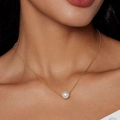 Elegant gold chain necklace with a single round white pearl pendant worn by a model - Single Large Pearl Pendant Necklace