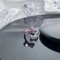 Close-up of silver bow ring with pink heart stones on a dark reflective surface - Style 6 Adjustable Ring