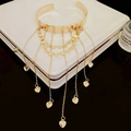 Macro shot of gold star heart tassel arm cuff placed on a premium jewelry box - Heart Shape / Gold