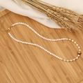 Dettaglio della collana con perle bianche, perline dorate e pendente a cuore su legno - 3# Cuore di Occhio di Tigre