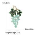 Elegant gold grape brooch with blue rhinestones and green leaves on white background - Green