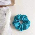 Peacock blue satin scrunchie with silky finish and pleat detail on wooden background - Satin Lake Blue
