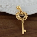 Gros plan d'un pendentif clé en forme de cœur plaqué or 24K sur une surface en bois - Clé Décorative / Or