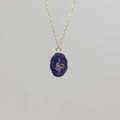 Macro detail of gold necklace featuring oval lapis lazuli pendant with a gold snake motif - Lapis Lazuli-Snake