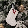 White cable knit Christmas stocking with embroidered red letter Q hanging on a tree - Embroidered Knitted Small Sock White Q