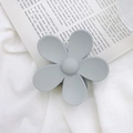 Detail of a large matte Morandi grey flower hair claw clip on vintage newspaper - Gray