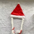 Detail of red plush Christmas hat featuring long white braided tassels with red ribbon bows - With Braids And Bows / Red Braided Style