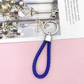 Blue braided leather keychain with silver metal ring and lobster clasp on pink background - Dark Blue