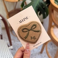 Detalle de una pinza para el pelo de pana marrón en forma de corazón con lazo verde y AE - Pinza para el cabello / Pinza de Cocodrilo de Corazón de Pana Marrón