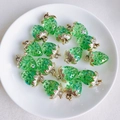 Close-up of green resin strawberry charms with gold leaves in a white ceramic dish - 7# Green With Bubbles