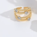 Close-up of golden spiral open ring featuring silver star accents and inlaid zircons - Star Hollow
