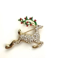Golden reindeer brooch with green enamel antlers and sparkling crystals on white background - Rhinestone Christmas Elk